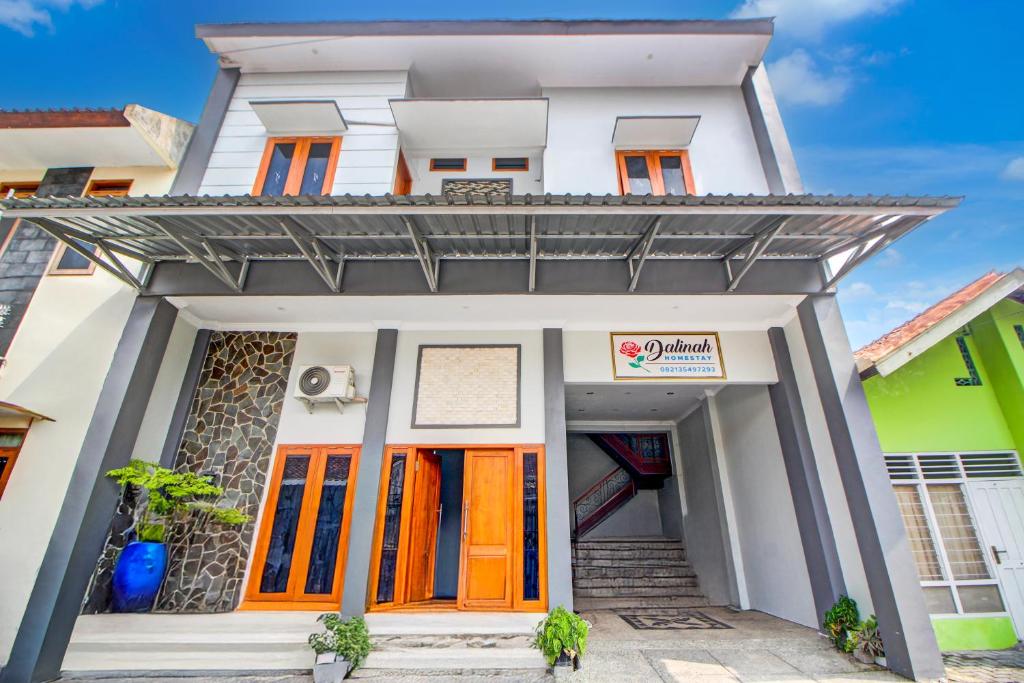 een huis met oranje deuren ervoor bij OYO 94364 Dalinah Homestay in Yogyakarta