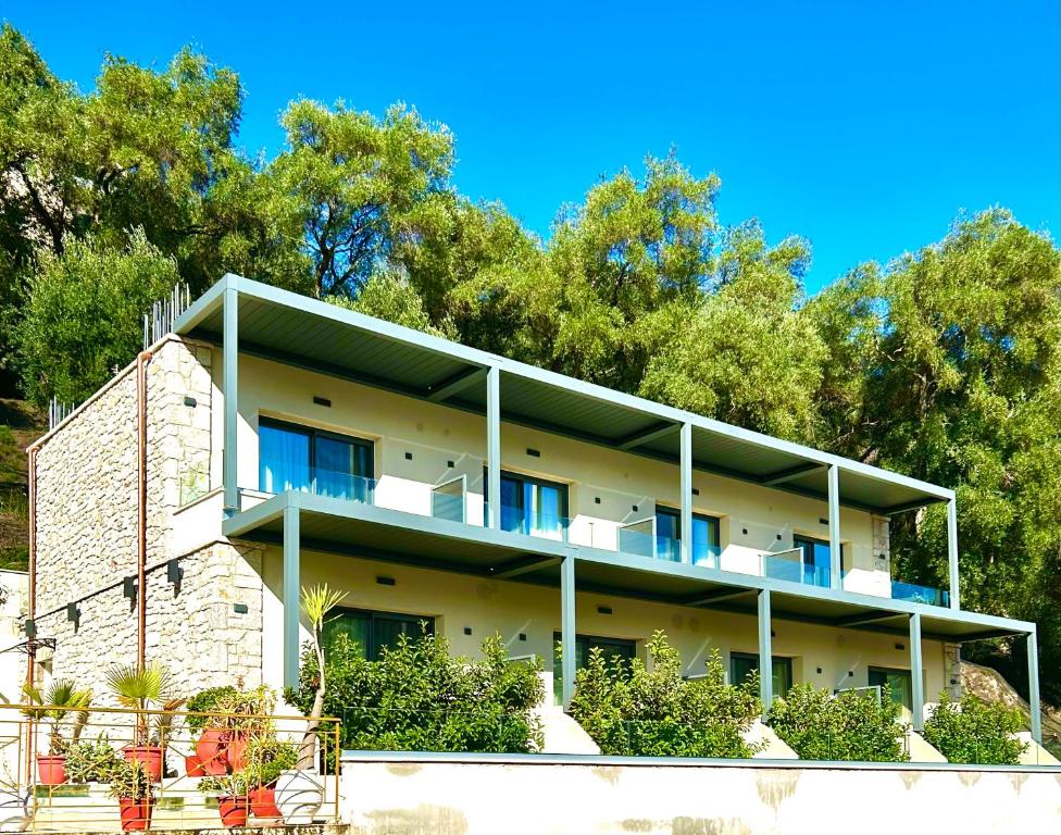 un gran edificio con árboles en el fondo en Tramonto Maisonettes & Suites, en Parga