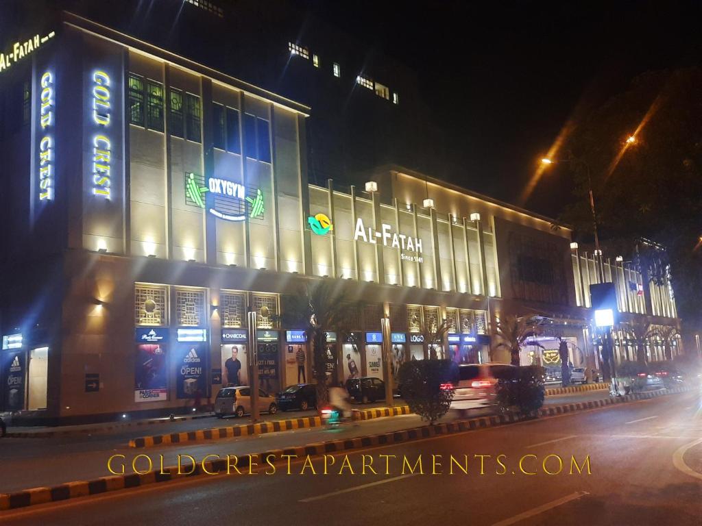 een gebouw in een stadsstraat 's nachts bij Goldcrest Luxury Apartments in Lahore