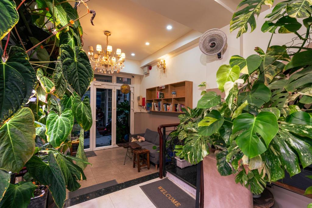 una habitación con muchas plantas y una lámpara de araña en Amango Home, en Ho Chi Minh