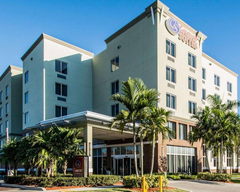 een hotel met palmbomen ervoor bij Comfort Suites Miami Airport North in Miami