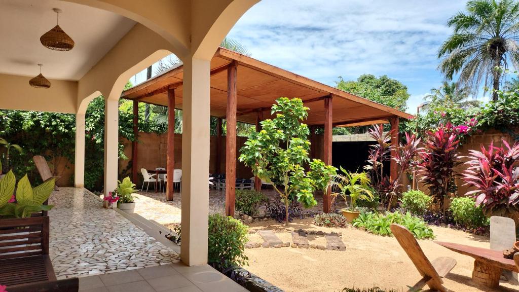 um pátio exterior com um pavilhão de madeira com plantas em POMBO KUNDA em Sanyang