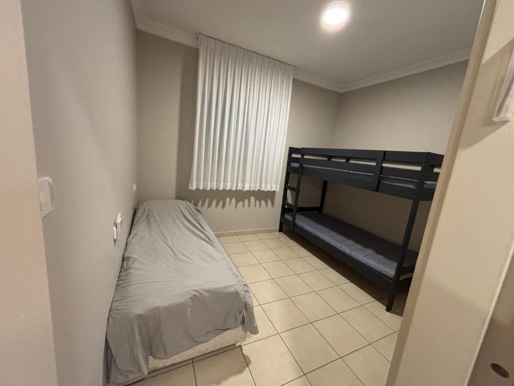 a small bedroom with a bunk bed and a tiled floor at Mediterranean Sea View in Ashqelon