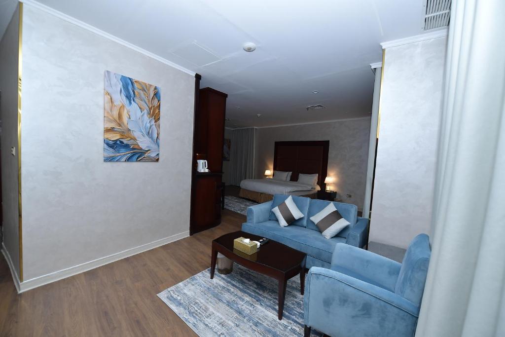 a living room with a blue couch and a bed at Palazzo hotel in Kuwait