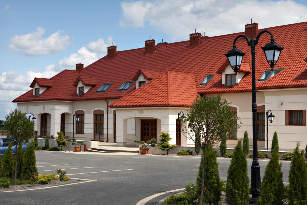 duży budynek z czerwonym dachem w obiekcie Hotel Trzy Róże w mieście Lublin