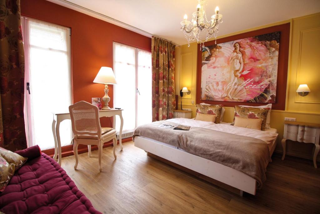 a bedroom with a large bed and a couch at Hotel Roses in Strasbourg