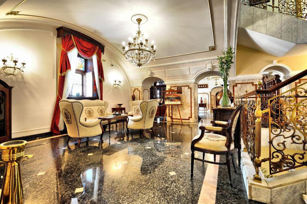 a dining room with a table and chairs and a chandelier at Hotel Leopold I in Novi Sad