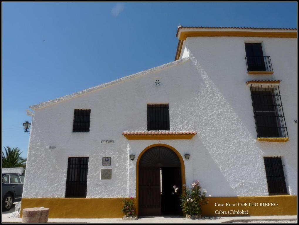 un edificio blanco con una puerta delante en Cortijo Ribero, en Cabra