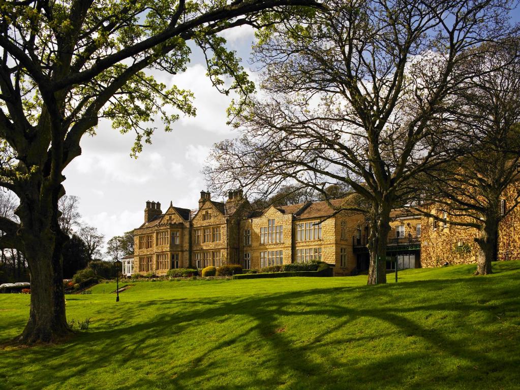 an old house with trees in front of it at Hollins Hall Hotel, Golf & Country Club in Bradford