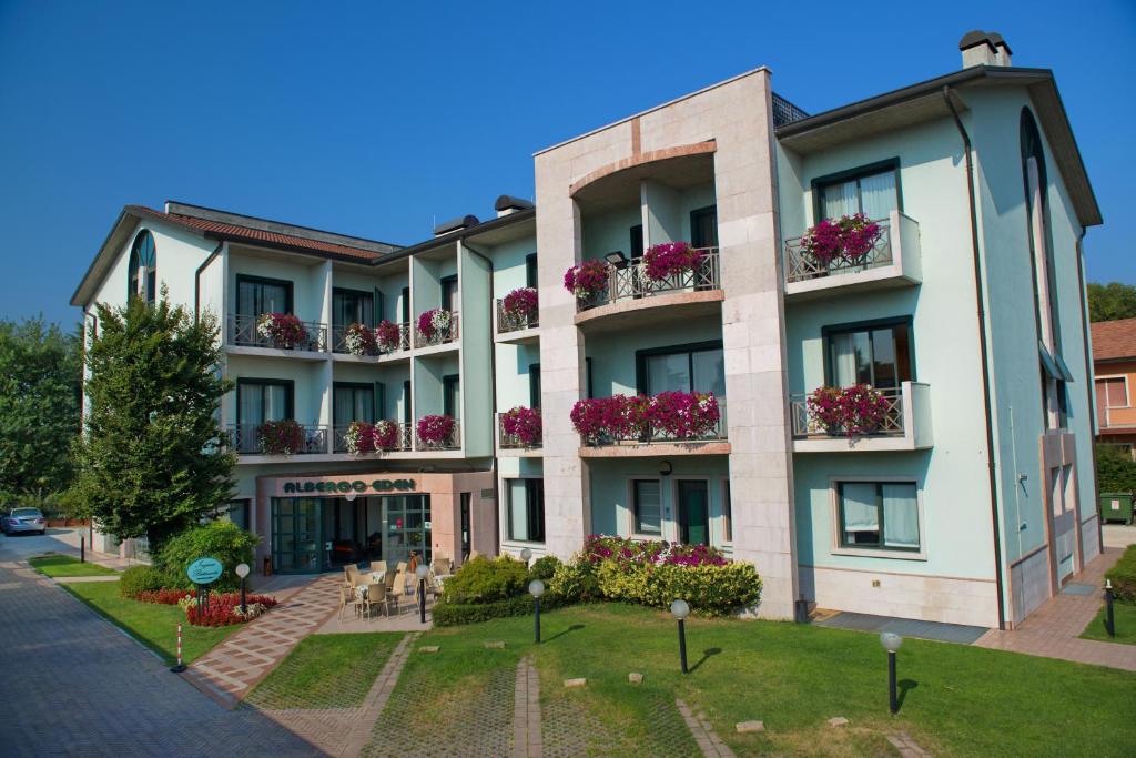 een appartementencomplex met bloemen op de balkons bij Hotel Eden in Valeggio sul Mincio