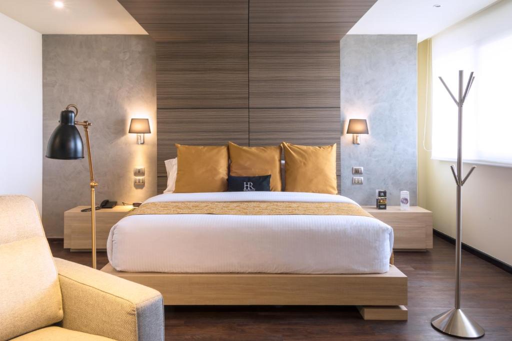 a bedroom with a large bed and a couch at Hotel Riazor Aeropuerto in Mexico City