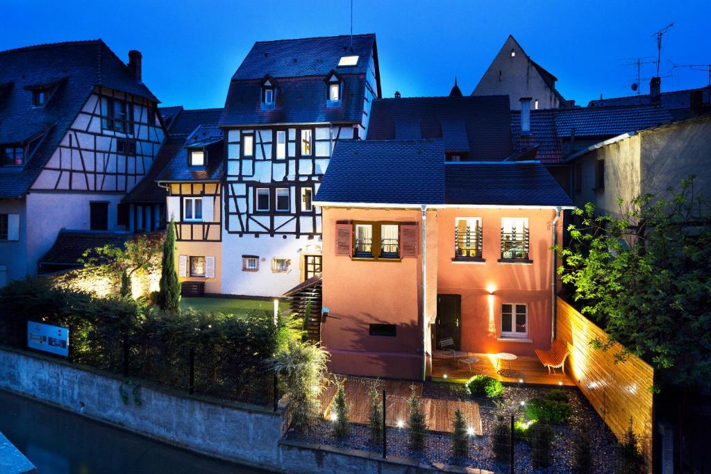 une maison dans une ville la nuit dans l'établissement Hotel Le Colombier Suites, à Colmar