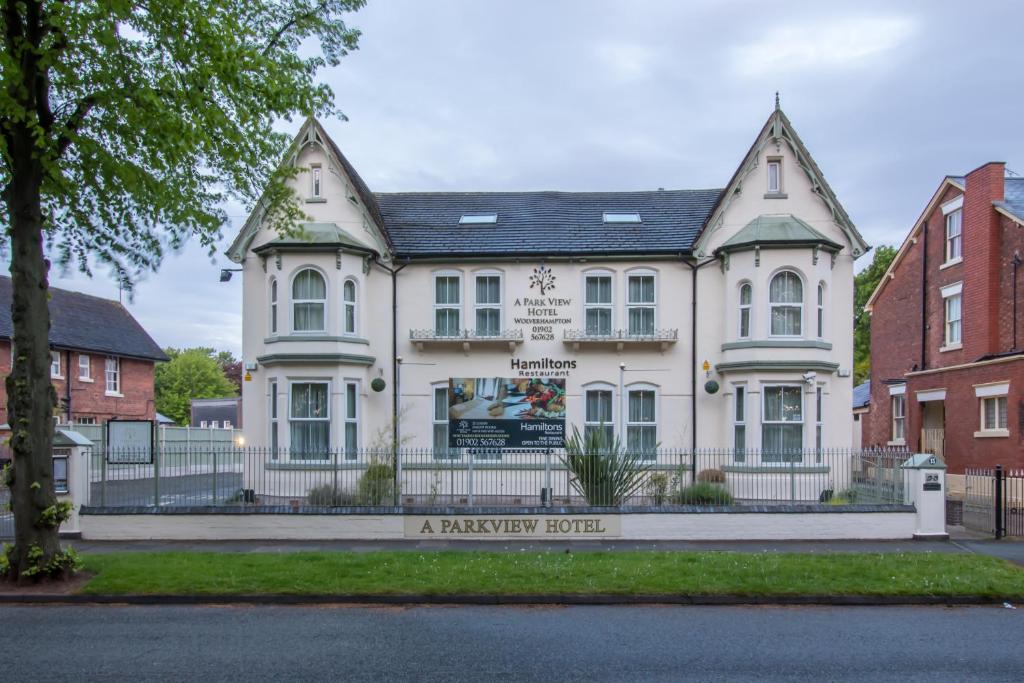 een wit gebouw met een bord ervoor bij A Park View Hotel in Wolverhampton