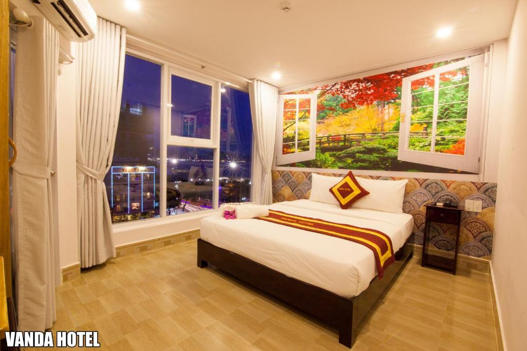 - une chambre avec un grand lit et une fenêtre dans l'établissement VANDA Hotel Nha Trang, à Nha Trang