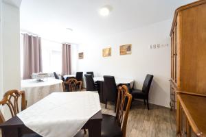 a dining room with tables and chairs and a piano at Villa Gradski Vrt in Osijek