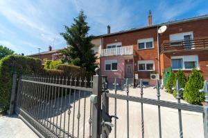 a metal fence in front of a brick building at Villa Gradski Vrt in Osijek