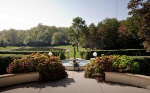 einen Garten mit einem Brunnen und einigen Büschen und Blumen in der Unterkunft The Belvedere Inn & Restaurant in Saugatuck