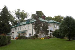 ein großes weißes Haus mit grünem Dach in der Unterkunft The Belvedere Inn & Restaurant in Saugatuck