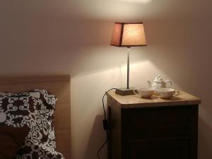 a lamp on top of a dresser next to a bed at La Casa di Aurora in Reggio di Calabria