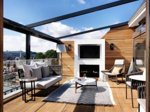 a balcony with a couch and a fireplace at The Marylebone Hotel in London