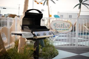 een barbecue naast een hek bij The StarLux in Wildwood