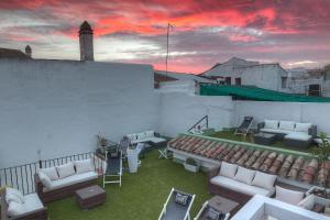 un patio en la azotea con sofás y sillas en un edificio en Los Patios, en Córdoba