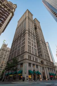 een hoog wit gebouw met groene luifels bij Magnolia Hotel Downtown Dallas in Dallas