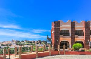 a brick building with a fence in front of it at Hotel Colina Dos Mouros in Silves