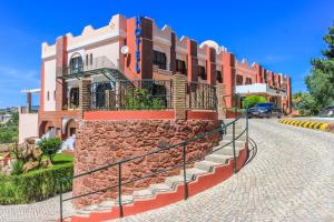 a stone wall with stairs in front of a building at Hotel Colina Dos Mouros in Silves