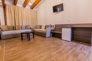 a living room with a couch and a tv at Il Semaforo Sila Hotel in Taverna