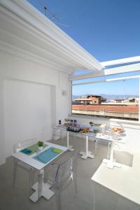 a white room with two tables and a large window at Domus Nova in Reggio di Calabria