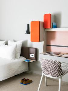 a bedroom with a bed and a desk with a laptop at Okko Hotels Strasbourg Centre in Strasbourg