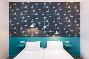 2 Betten in einem Zimmer mit einer Wand und Sonnenschirmen in der Unterkunft Hotel Marsiho by Happyculture in Marseille