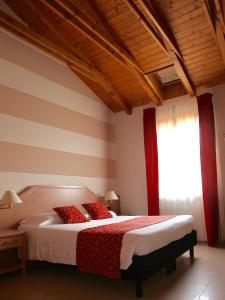 a bedroom with a bed with red pillows and a window at Santanna in Verbania