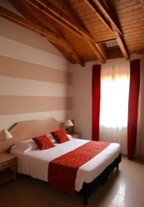 a bedroom with a bed with red pillows and a window at Santanna in Verbania