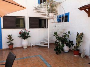 un patio con macetas y una escalera y ventanas en Panorama Hotel, en Ammoudia