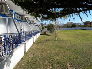 un edificio con un patio de césped junto a una pared en Panorama Hotel, en Ammoudia