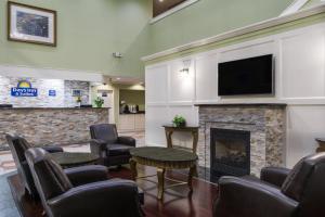 sala de estar con chimenea y TV de pantalla plana en Days Inn by Wyndham Columbus East Airport, en Columbus