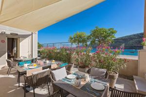 um pátio exterior com mesas, cadeiras e flores em Boutique Hotel Adoral em Rabac