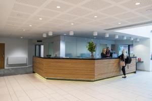 a lobby with people standing at a reception counter at Warwick Conferences - Radcliffe in Coventry