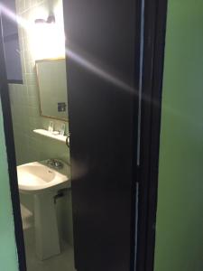 a bathroom with a sink and a black door at Hotel Oxford in Mexico City