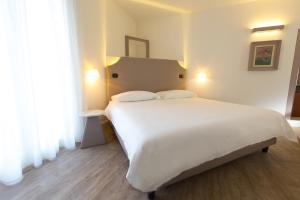 a bedroom with a large white bed with two pillows at Hotel Al Campanile - Luxury Suites & Apartments in Baveno