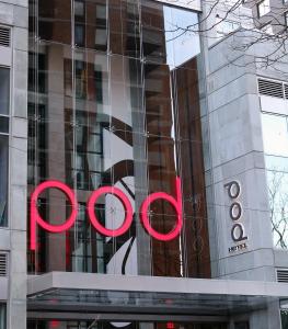 een groot glazen gebouw met een rood bord erop bij Pod Times Square in New York