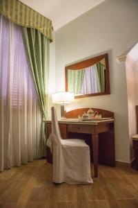 a desk with a mirror and a chair in a room at Palmed Hotel in Gizzeria