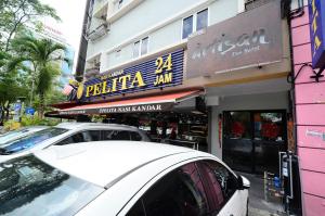 a white car parked in front of a store at Artisan Eco Hotel in Petaling Jaya