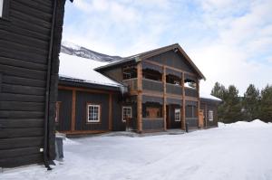 un grande edificio in legno con neve sul terreno di Toftemo Turiststasjon a Dovre