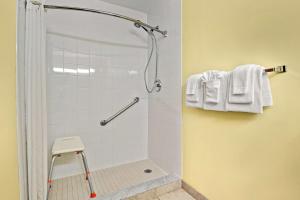 a bathroom with a shower with white tiles at Super 8 by Wyndham Barrie South in Barrie