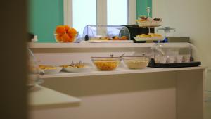 a shelf with bowls of food and other foods at Domus Nova in Reggio di Calabria