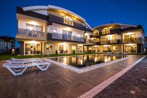 um grande edifício com uma piscina em frente em Lara Beach Homes em Antália