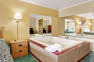 a large bathroom with a tub and two sinks at Days Inn by Wyndham Knoxville West in Knoxville